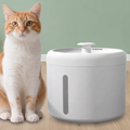 Quiet USB pet water fountain in white beside an orange and white cat